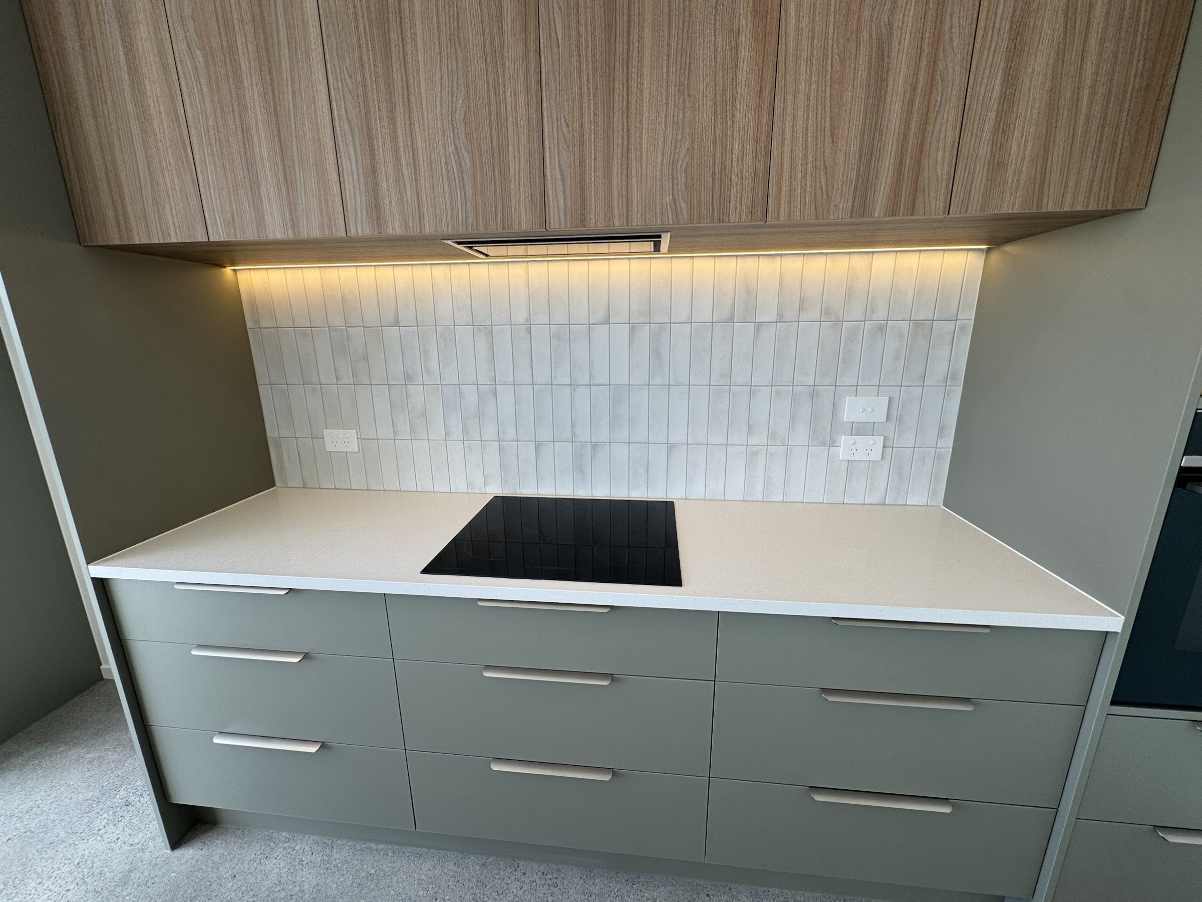 Detailed view of the cooktop, tiled splashback and kitchen joinery