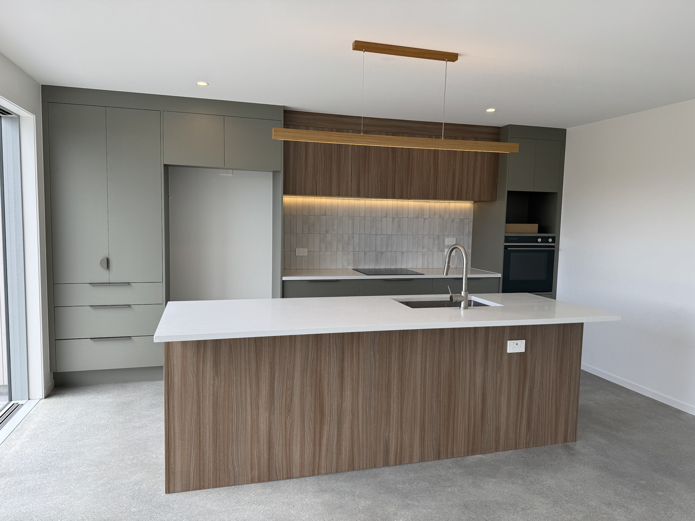 Wide view of the finished kitchen and island in House 43