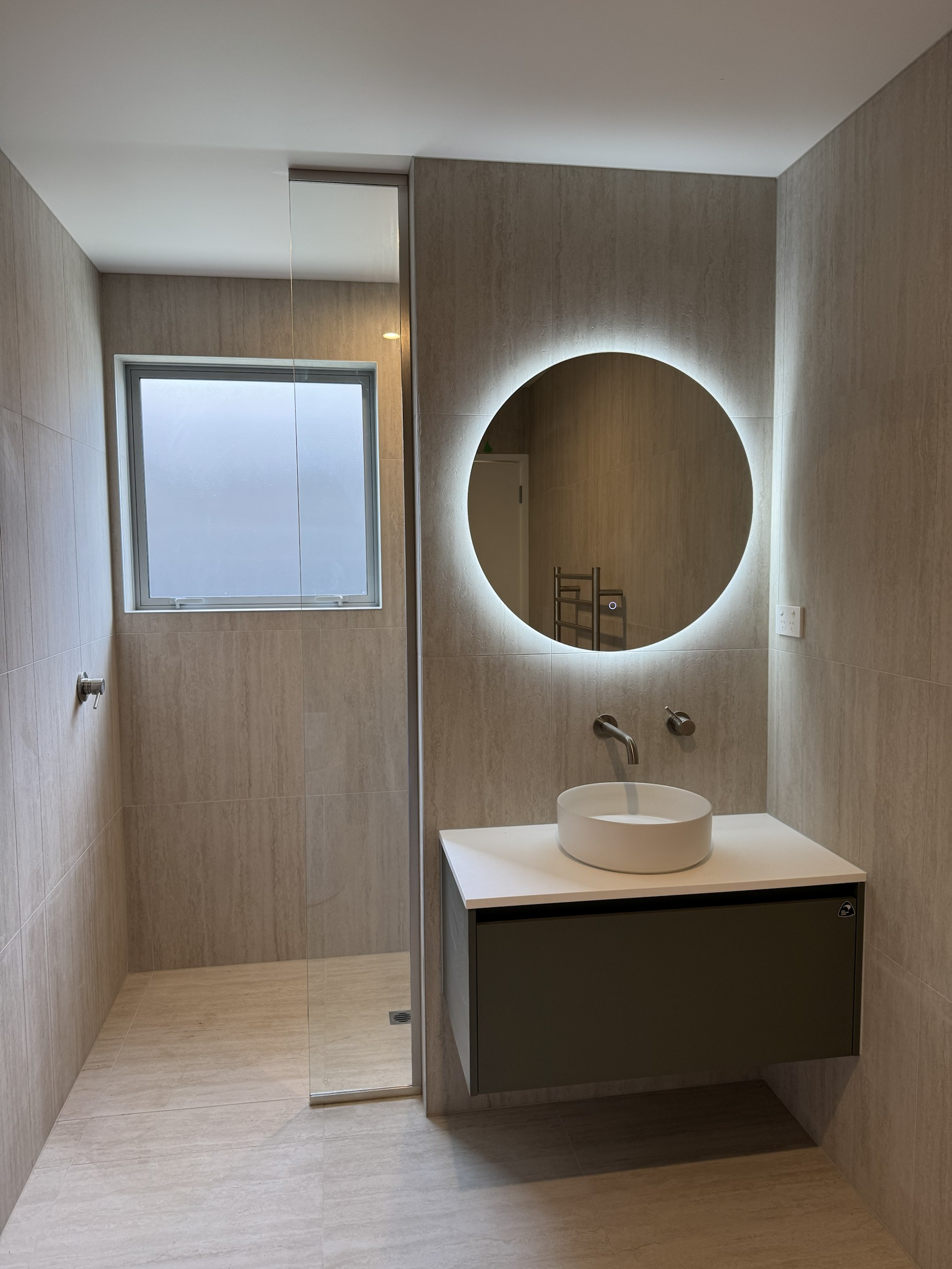 Green Slate wall-hung vanity with illuminated round mirror
